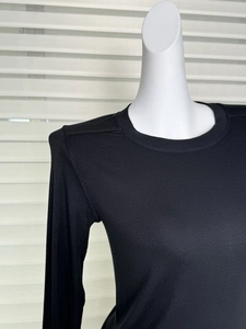 Detail of black long-sleeved rib-knit top showing fine wool Tencel fabric texture