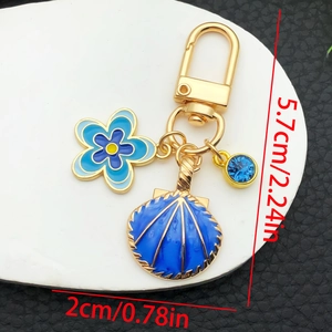 Détail montrant les dimensions du porte-clés coquillage et fleur en émail bleu doré