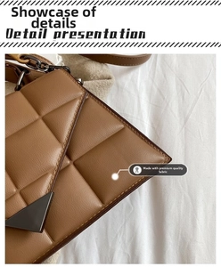 Detail of brown quilted leather shoulder bag with triangle metal buckle and chain strap