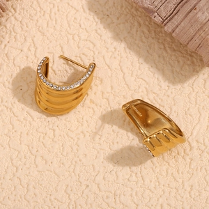 Macro shot of 18K gold plated earring featuring sparkling micro-paved zircons on wave edges
