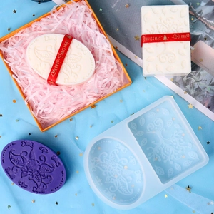 Detail of soap mold featuring ethnic floral patterns with finished soaps in festive gift box