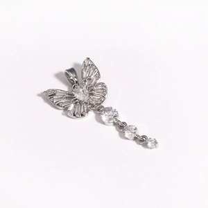 Macro detail of silver butterfly pendant with cubic zirconia inlay and tassel chain