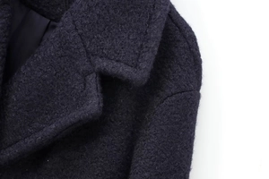 Close-up of wool-blend texture on double-breasted coat collar and shoulder seams