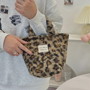 Detail of leopard print faux fur handbag with colorful brand tag on soft texture