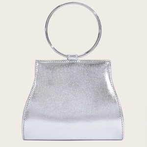 Detail view of a silver trapezoidal evening bag with a large round metal ring handle