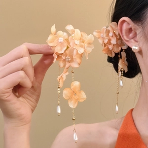 Detail of fabric flower hair clip with elegant pearl tassels in soft peach tone