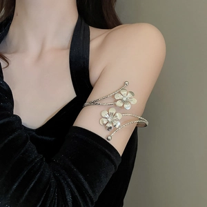 Detail of flower armlet featuring pearlescent petals and braided silver texture