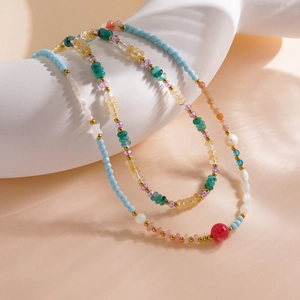 Macro detail of multi-color gemstone beads with star motifs and pearls on stainless steel chain