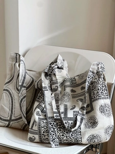 Detailed texture of printed cotton linen tote bags with adjustable straps on a white chair