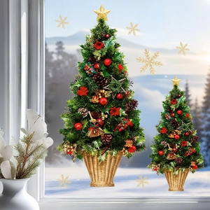 Set of two decorative Christmas trees with red berries and gold stars on a snowy window