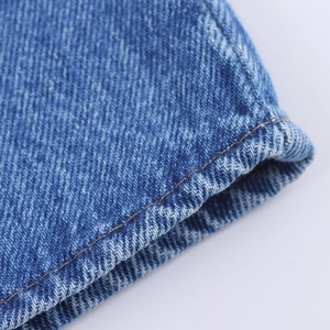 Detailaufnahme von dunkelblauem Denim-Stoff mit verstärkter gelber Doppelnaht