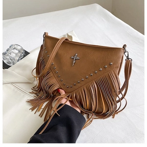 Vue détaillée du sac à franges marron avec rivets métalliques et pendentif croix