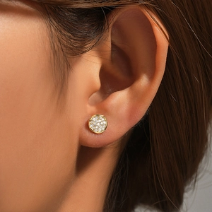 Close-up of classic 925 sterling silver gold round stud earrings with shimmering zircons
