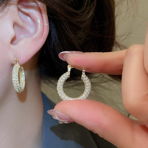 Macro shot of gold-plated U-shaped earrings featuring micro-pave cubic zirconia stones