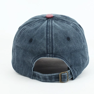 Detail view of washed navy baseball cap with a dark red top button and metal adjustable strap