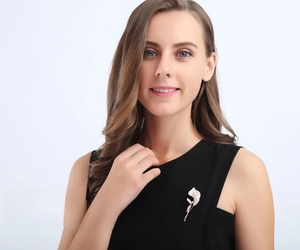 Elegant silver calla lily brooch with shimmering crystals worn on a blazer lapel