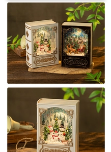 Close-up of vintage book-shaped Christmas lantern with warm LED light and snow globe scene