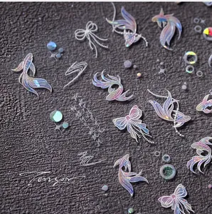 Macro shot of 3D holographic nail stickers with golden fish and butterfly motifs