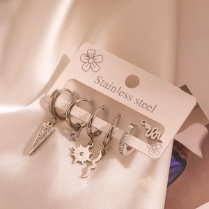 Detailed set of six silver stainless steel earrings with zircon charms on silk fabric