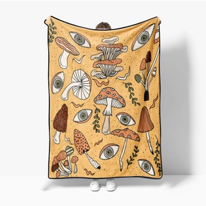 Detail showing vintage yellow flannel blanket with mushroom and eye prints and soft texture
