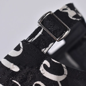 Detail of adjustable silver metal buckle on a black fabric strap with white pattern