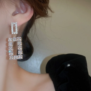 Close-up of model wearing luxury geometric double square gold earrings with clear zircons