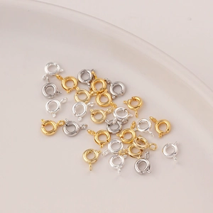 Makroaufnahme von 14K Gold- und Silber-Federringen auf einer weißen Keramikplatte