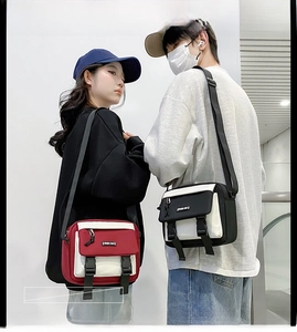 Detail of cross-body bags with flap double buckle design in black and red contrast colors