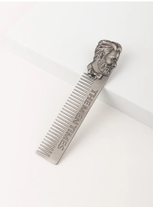 Detail of silver metal beard comb with Men Times engraving and embossed gentleman logo