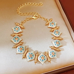 Detailed view of vintage gold enamel bracelet with blue rhinestones in a silk-lined gift box