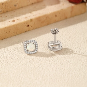 Square S925 silver stud earrings with white opal center and zircon halo on beige stone