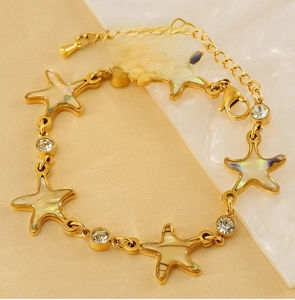 Detail view of 18K gold starfish bracelet with mother of pearl inlay and crystal accents