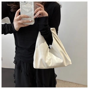 Detailed view of cream PU leather cloud bag with elegant pleated texture and soft finish