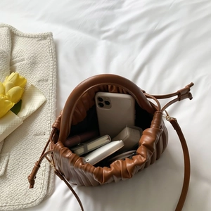 Top view of brown pleated cloud bag showing large capacity with phone and notebook