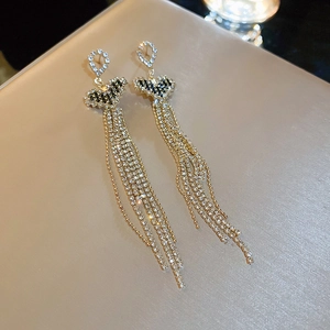 Close-up of golden tassel earrings featuring sparkling rhinestones and elegant long fringes