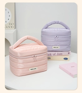 Dettaglio di pochette per cosmetici trapuntate in nylon rosa e lilla con effetto imbottito