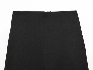 Close-up detail of the waistline and dense fabric texture on a black French knot skirt