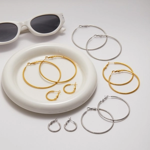 Detailed set of gold and silver stainless steel hoop earrings in various sizes on white background