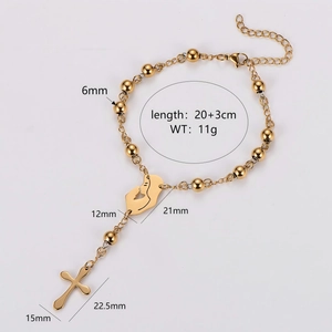 Gold beaded bracelet with cross and portrait pendants on a clean white background