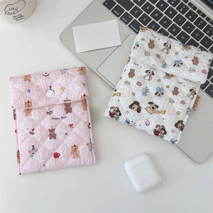 Close-up of quilted bear and puppy sanitary storage pouches with button closure