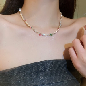 Gros plan du collier choker en acier argenté avec perles colorées et reflets brillants