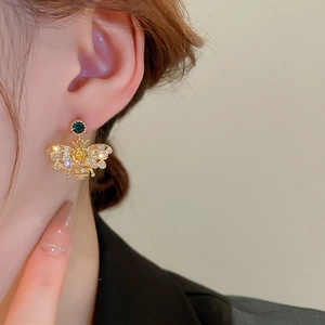 Detail showing gold bee earring with sparkling crystals and vibrant gemstones on ear