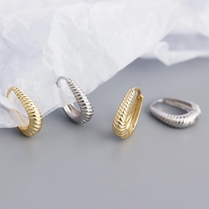 Detailed view of S925 sterling silver twisted hoop earrings in gold and silver finishes