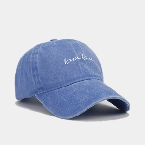 Nahaufnahme der weißen Baba-Stickerei auf gewaschener blauer Denim-Baseballkappe