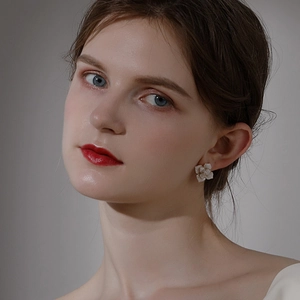 Elegant camellia flower stud earrings with creamy petals on a model for a chic look