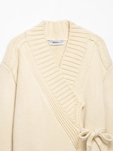 Close-up of heavy knit cream wrap cardigan showing ribbed lapel and texture