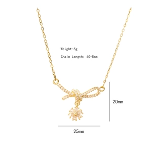 Elegant gold bow and flower pendant necklace with diamonds and tassel details