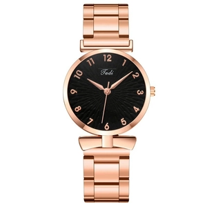 Close-up of rose gold steel watch dial with sunray texture and numeric markers