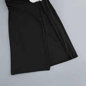 Detail of black dress featuring a large white flower accent and high slit fishtail hemline