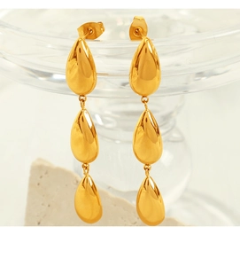 Detailed macro view of triple layered gold water drop earrings with mirror finish